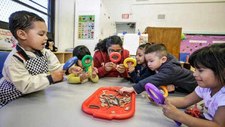 young children sit at a table with toys